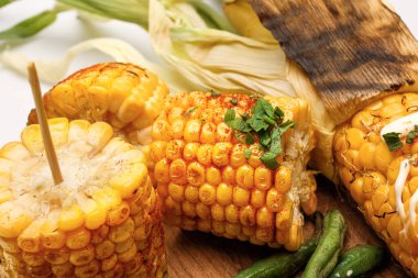 Beyaz arka planda lezzetli ızgara Meksika sokak mısırı parçaları, yakın plan.