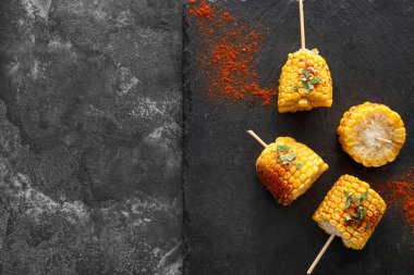 Siyah arka planda lezzetli ızgara Meksika sokak mısırı parçaları olan tahta.