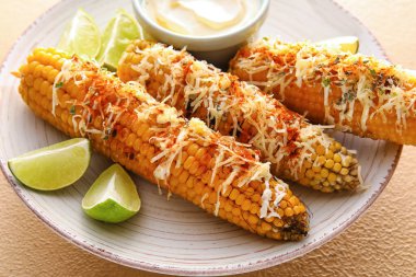 Lezzetli Elote Meksika sokak mısırı ve mayonez tabağı. Bej arka planda, yakın plan.