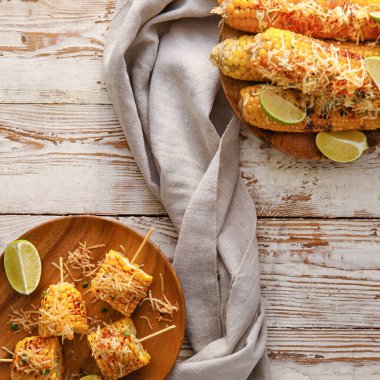 Beyaz ahşap arka planda lezzetli Elote Meksika Sokak Mısırı tabakları