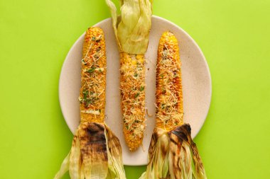 Yeşil arka planda lezzetli Elote Meksika sokak mısırı tabağı