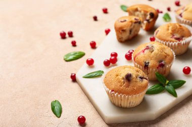 Bej arkaplanda lezzetli yaban mersinli kekler olan tahta