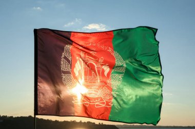Nehir kenarında Afganistan bayrağı sallıyor