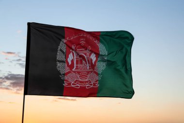Mavi gökyüzüne Afganistan bayrağı sallayarak