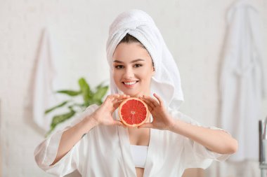 Banyoda greyfurtlu güzel bir genç kadın.