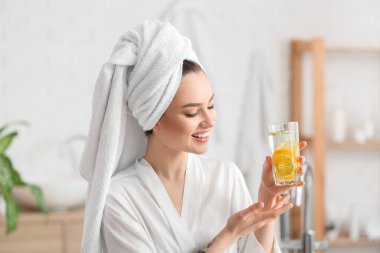 Evde taze limonatası olan güzel genç bir kadın.