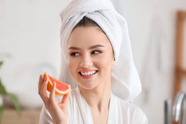 Banyoda greyfurtlu güzel bir genç kadın.