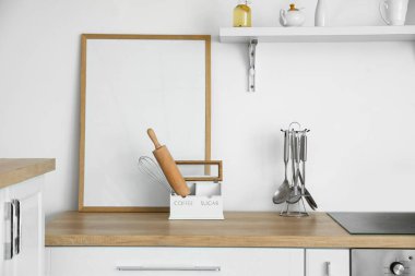 Işık duvarının yanındaki mutfak tezgahında boş poster çerçevesi