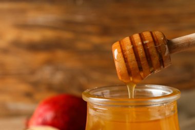 Tatlı bal kavanozu ve ahşap arka planda Dipper, yakın plan