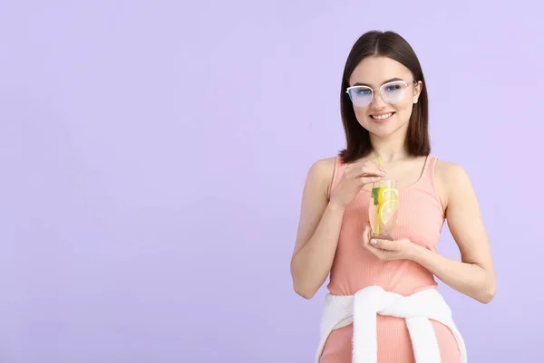 美丽的年轻女子 有新鲜的柠檬水和色泽背景 — 图库照片