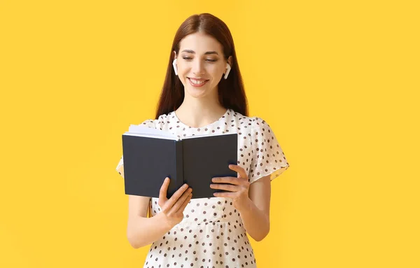 Νεαρή Γυναίκα Ακουστικά Και Βιβλίο Στο Φόντο Χρώμα — Φωτογραφία Αρχείου