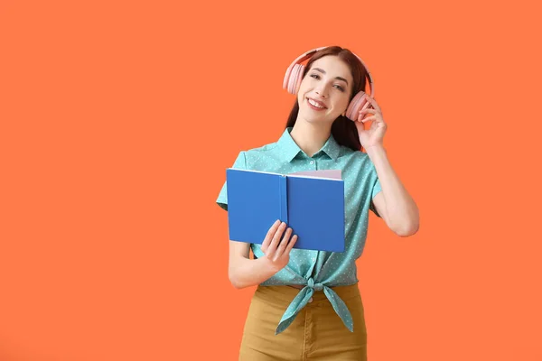 Junge Frau Mit Kopfhörer Und Buch Auf Farbigem Hintergrund — Stockfoto