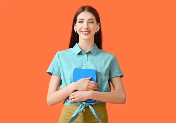 Junge Frau Mit Kopfhörern Und Buch Auf Farbigem Hintergrund — Stockfoto