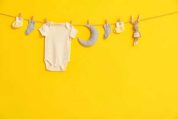 Stylish Baby Clothes Toys Hanging Rope Yellow Background — Stock Photo, Image