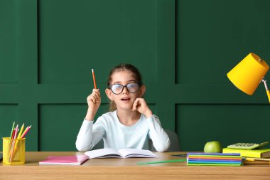 Masada ödev yapan küçük bir kız.