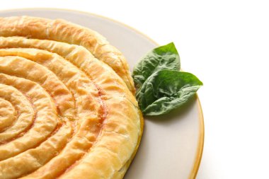 Beyaz arka planda lezzetli ıspanaklı turta, yakın plan.