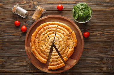 Ahşap arka planda lezzetli ıspanaklı turta kompozisyonu