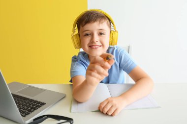 Masada ödev yapan küçük bir çocuk.