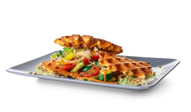 Beyaz arka planda soslu ve sebzeli leziz Belçika waffle 'ları.