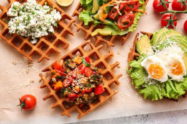 Açık arkaplanda Belçika waffle 'ı ve sebzeli parşömen