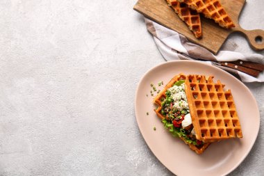 Açık arkaplanda yumurta, peynir ve sebzeli leziz Belçika waffle 'ları.