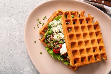 Açık arkaplanda yumurta, peynir ve sebzeli leziz Belçika waffle 'ları.