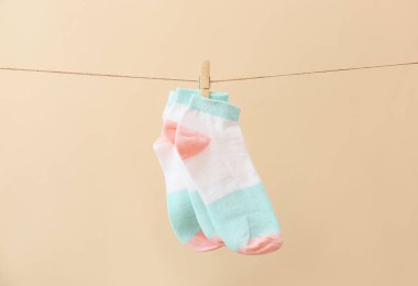 Arka planda çamaşır ipinde asılı bir çift çorap