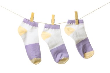 Beyaz arka planda ipte asılı üç çorap