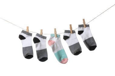 Beyaz arka planda ipte sallanan farklı çoraplar