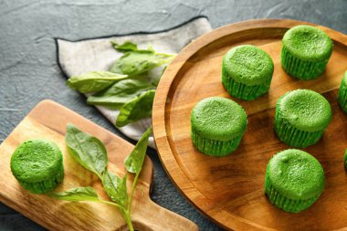 Koyu arka planda lezzetli ıspanaklı çöreklerle ahşap tezgah ve yemek, yakın plan.