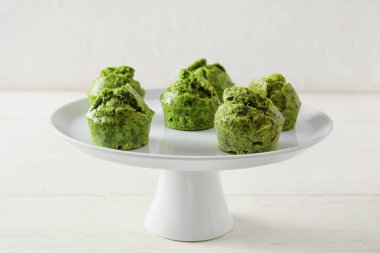 Hafif arka planda ıspanaklı çöreklerle durun.