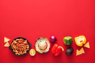 Lezzetli Fajita, sebze ve kırmızı arka planda sombrero şapkalı kompozisyon