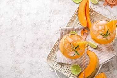 Hafif arka planda lezzetli kavun kokteyli bardakları olan tepsi