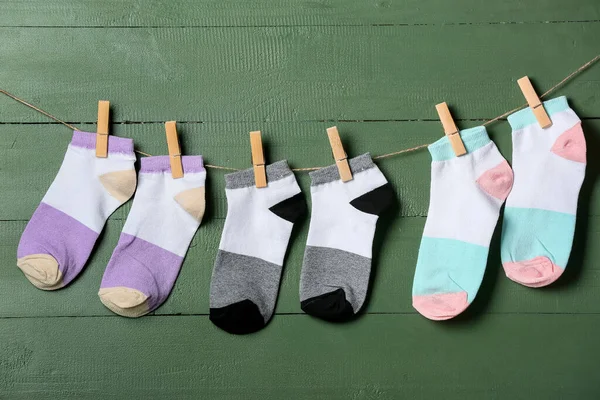 Різні Шкарпетки Висять Мотузці Зеленому Дерев Яному Фоні — стокове фото