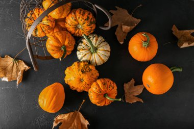 Arka planda balkabaklarıyla çevrilmiş sepet.
