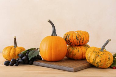 Masanın üzerinde olgun balkabakları ve üzümlerle kompozisyon