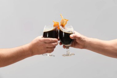 Gri arka planda bira bardakları olan eller
