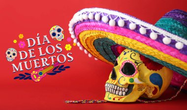 Meksika Ölüler Günü için boyanmış insan kafatası (El Dia de Muertos) ve renk arka planında sombrero şapka
