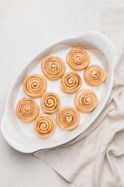 Beyaz arka planda pişmemiş tarçınlı fırın yemeği.