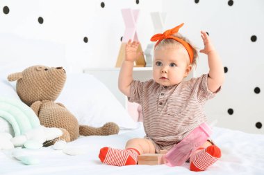 Yatak odasında sevimli bir kız bebek.