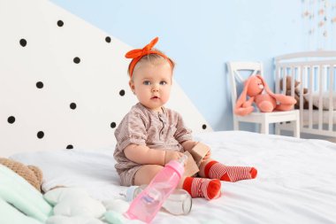 Yatak odasında sevimli bir kız bebek.