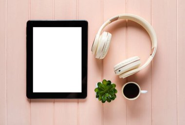Modern tablet bilgisayar, kulaklık ve kahve renkli ahşap arka plan