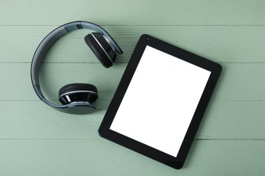 Renkli ahşap arka planda modern tablet bilgisayar ve kulaklıklar