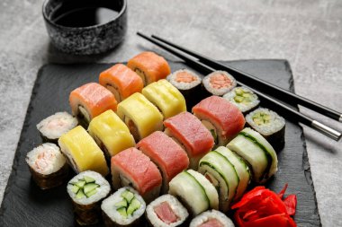 Bir dizi lezzetli suşi ruloları ve grunge arka planda çubuklar.