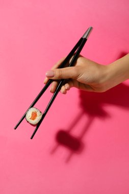 Elinde somon balıklı çubuk tutan kadın.