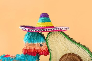 Mexican pinatas with sombrero hat on color background clipart