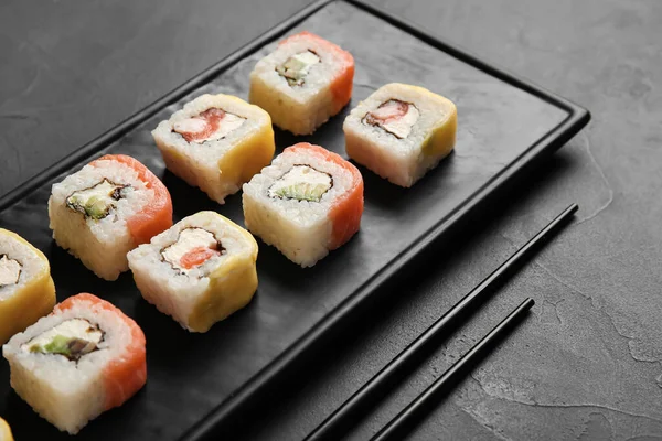 Tablero Con Deliciosos Rollos Sushi Palillos Sobre Fondo Oscuro Primer —  Fotos de Stock
