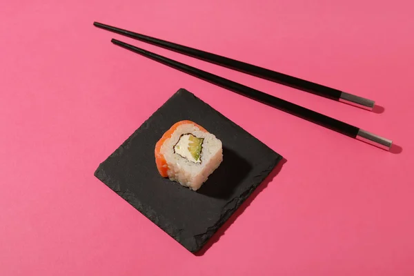 おいしい寿司ロールと箸で色の背景にボード — ストック写真
