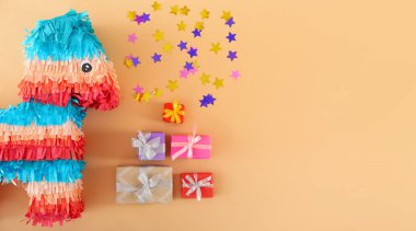 Konfetili Meksika pinyatası ve renkli arka planda hediyeler