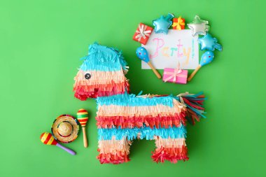 Meksika pinyatası, sombrero şapkası, marakas ve renkli arka planda hediyeler.